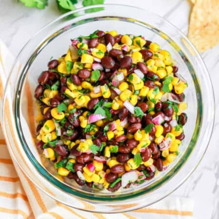 Black bean corn salsa overhead in a bowl with chips and cilantro