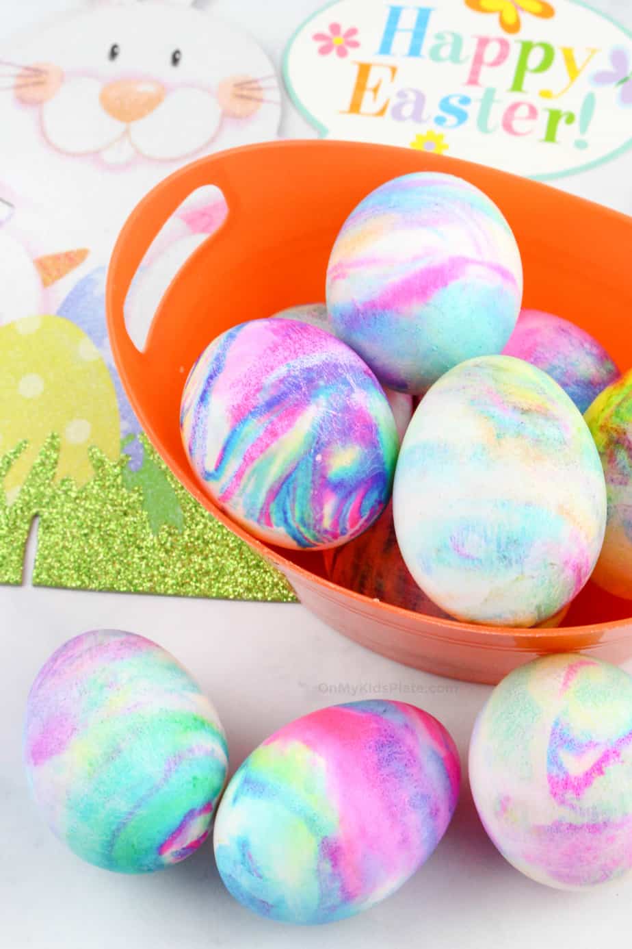 Marbled dyed colorful Easter Eggs in a basket and in front of the basket.