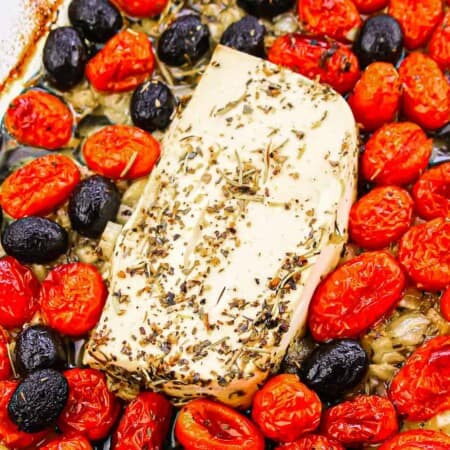 feta in a baking pan with roasted tomatoes and olives