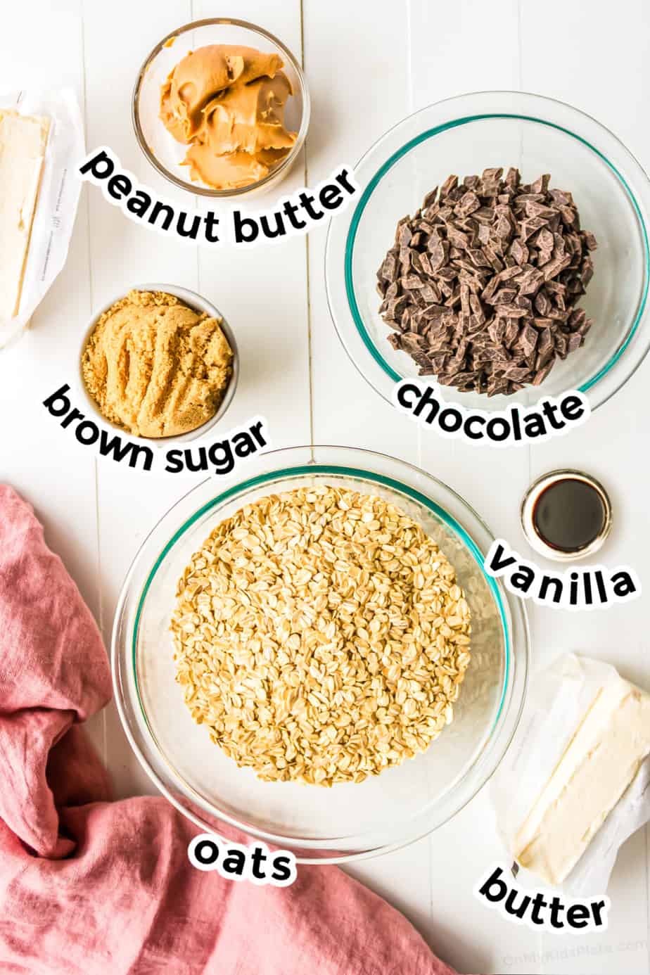 Ingredients for chocolate oat bars in bowls from overhead with labels.