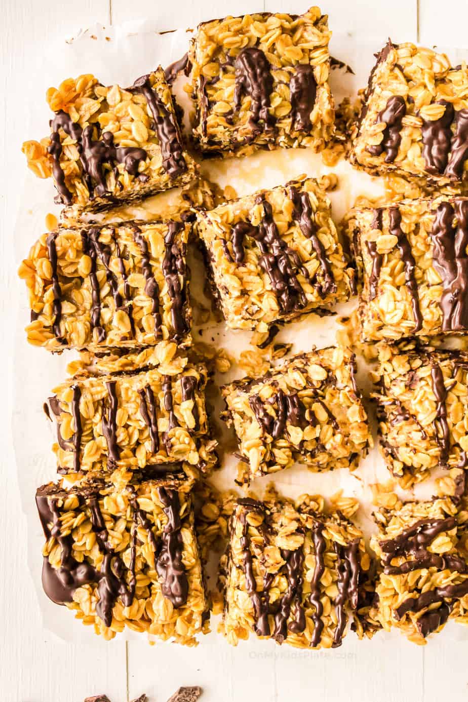 A batch of chocolate oat bars sliced on parchment paper from overhead