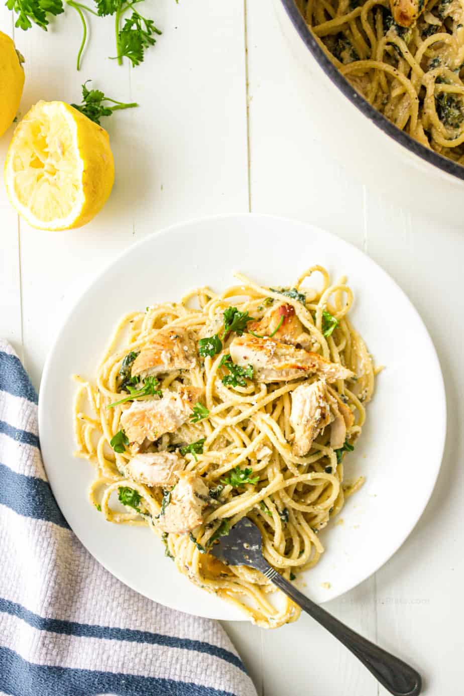 Spagehtti with chicken, lemon and herbs in a creamy sauce on a plate.