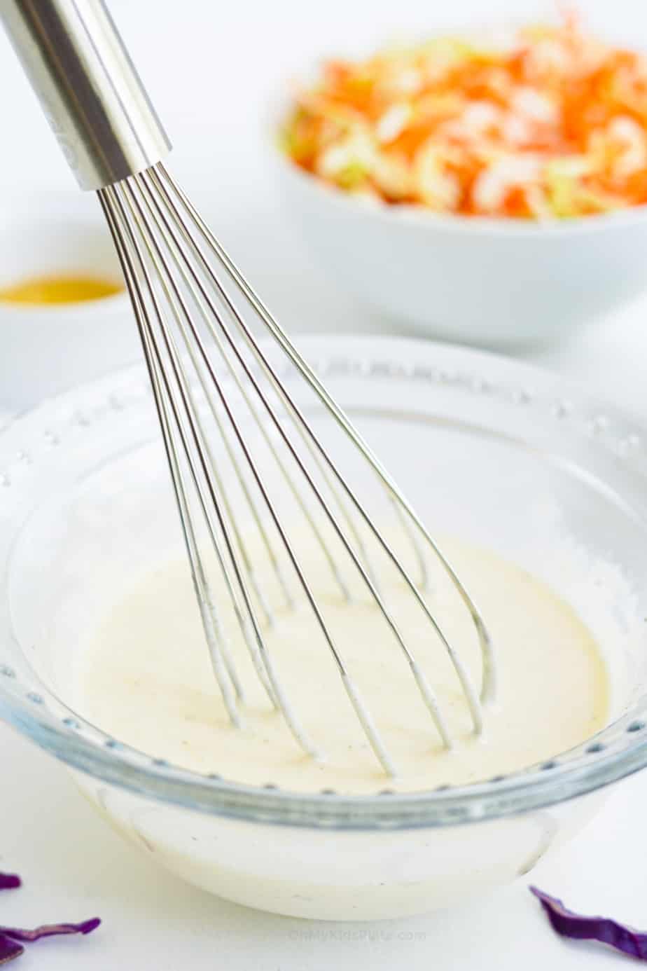 Mixing dressing in a small bowl with a whisk from the side