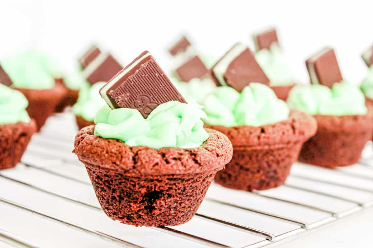 Chocolate cookie cups filled with mint frosting topped with a chocolate mint candy