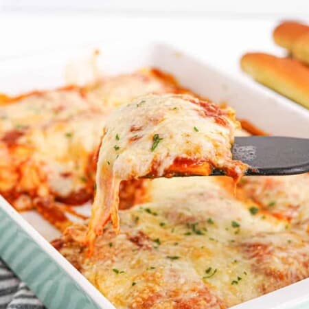 Ravioli casserole being served with a spatula from a baking dish