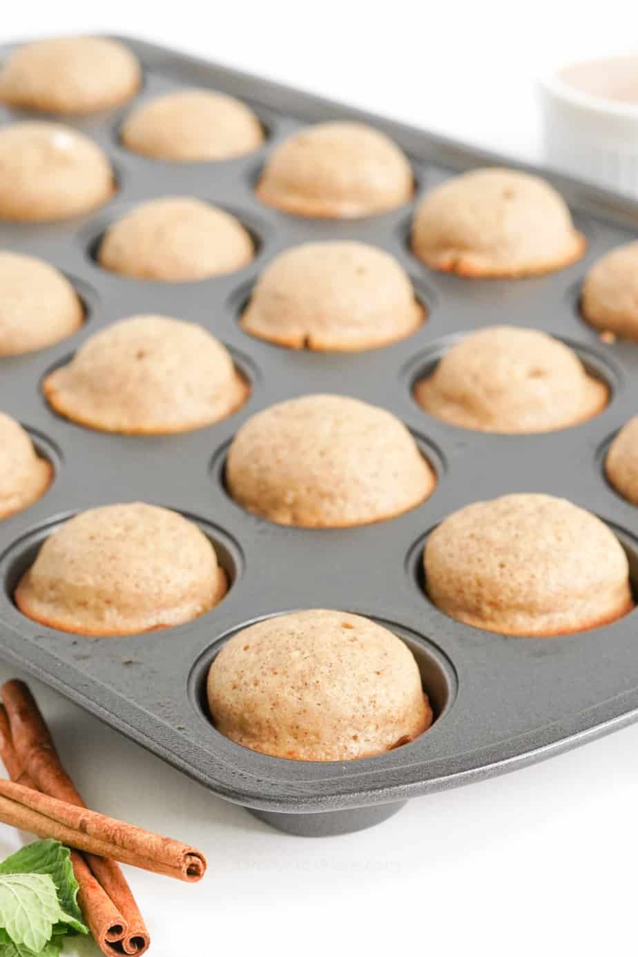 Baked doughnut holes in a mini muffin pan from the side.