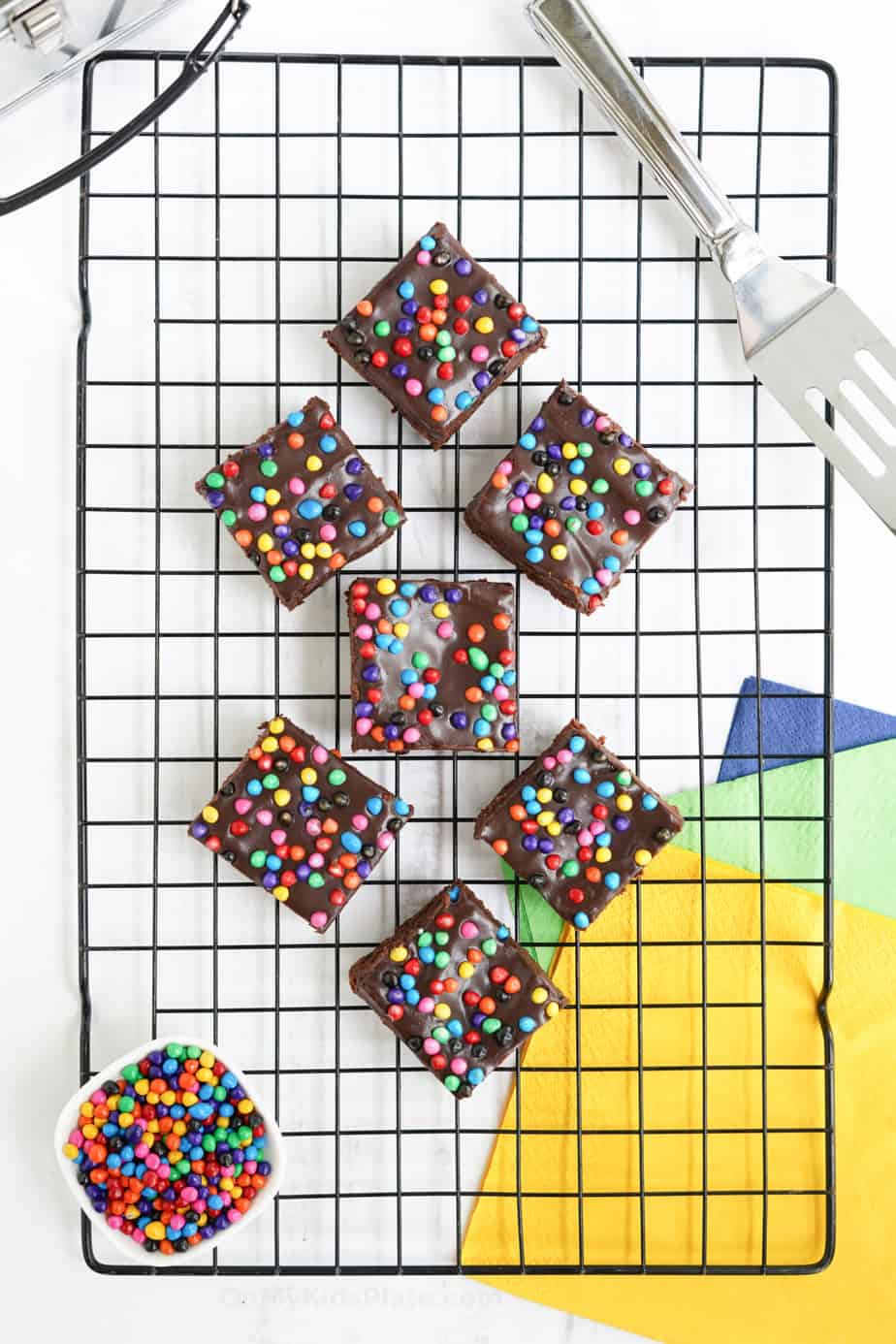 Brownies with rainbow sprinkles sliced on a cooling rack