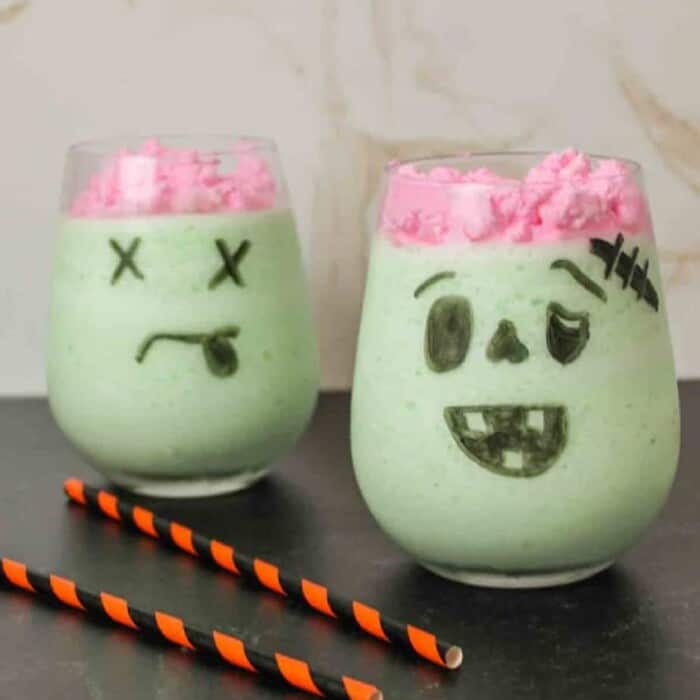 Green monster shaped drink with pink whipped cream to look like brains.