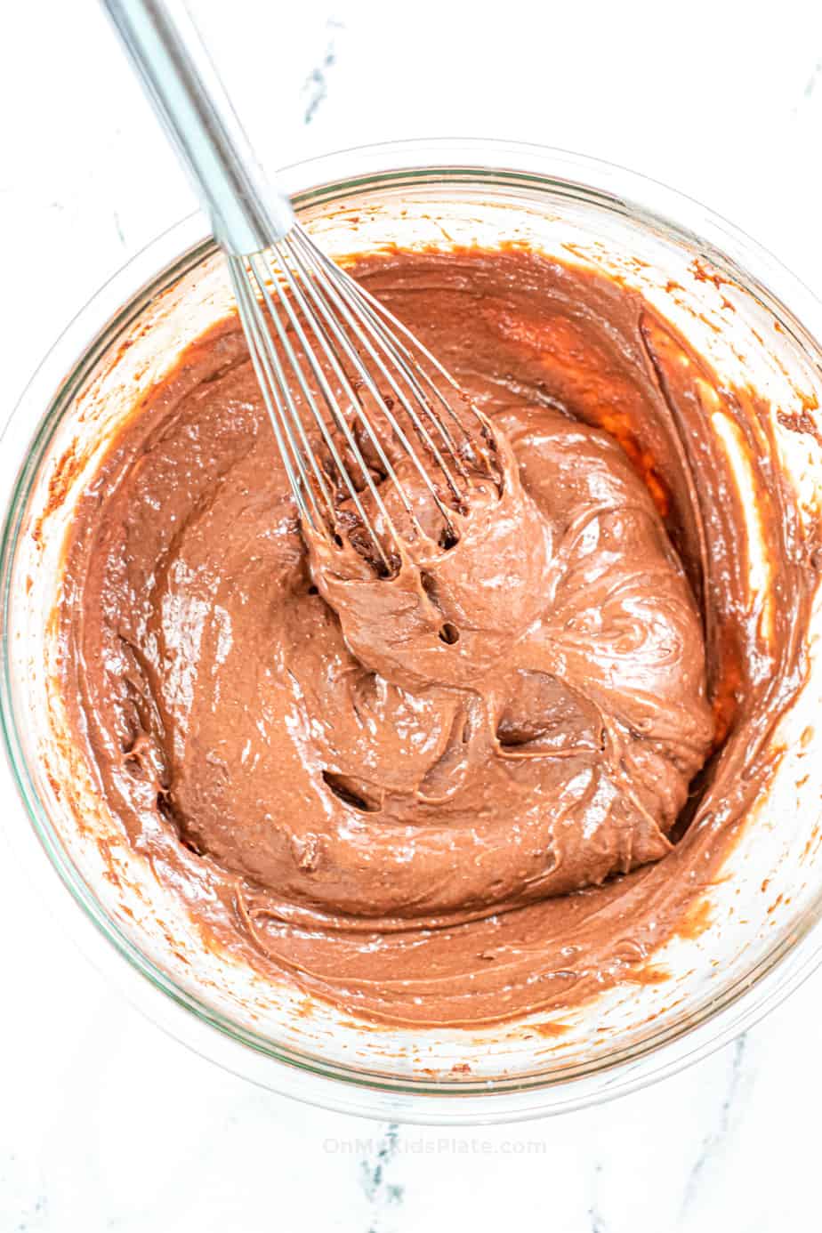 Mixing chocolate pudding in a bowl with a whisk.