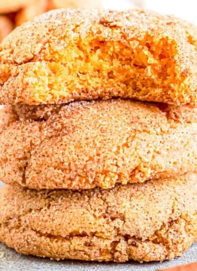 Pumpkin snickerdoodle cookies stacked with a bite out of the top cookie close up