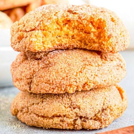 Pumpkin snickerdoodle cookies stacked with a bite out of the top cookie close up