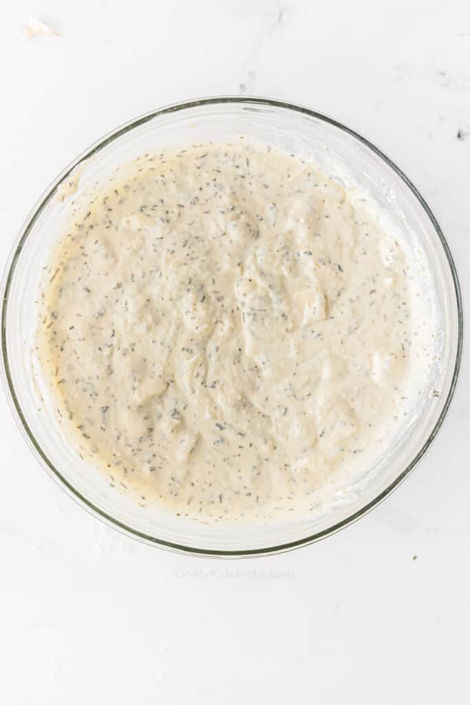 Ricotta cheese mixed with herbs in a large bowl for a meatless baked ziti recipe.