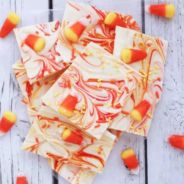 Pieces of white chocolate bark with candy corn on top and candy corn colors swirled throughout.