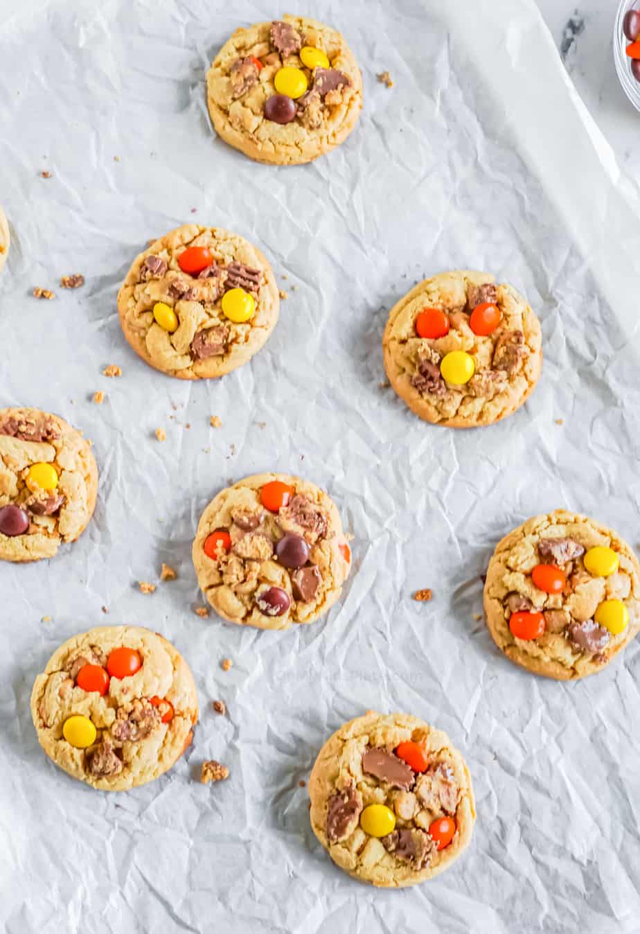 Cookies baked on the pan with peanut butter cups and Reese's pieces pressed into the top of the cookies.