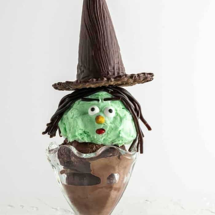 Ice cream sundae decorated like a witch with a green face from the side
