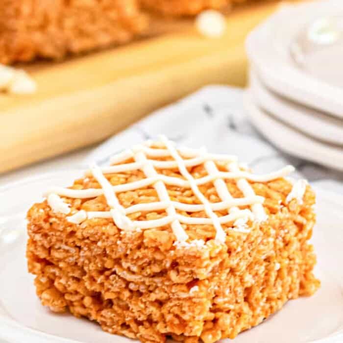pumpkin spice rice krispie treat drizzled with white chocolate on a plate