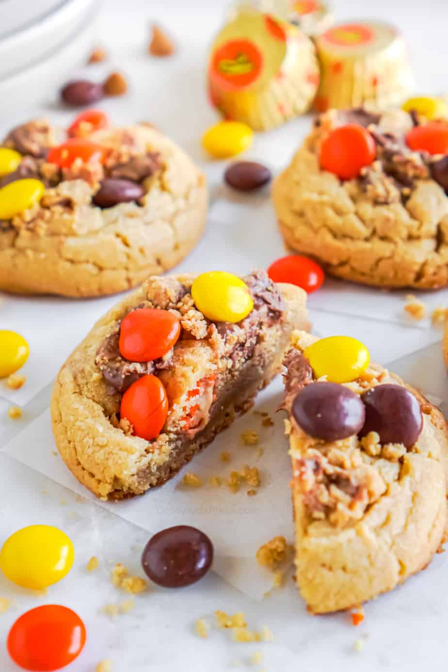 Cookie slices in half to see the inside up close covered in peanut butter candies and pieces of peanut butter cups