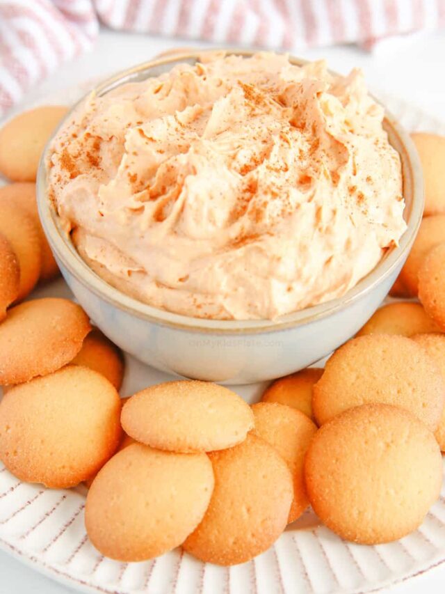 A bowl of pumpkin dip with cookies on a plate