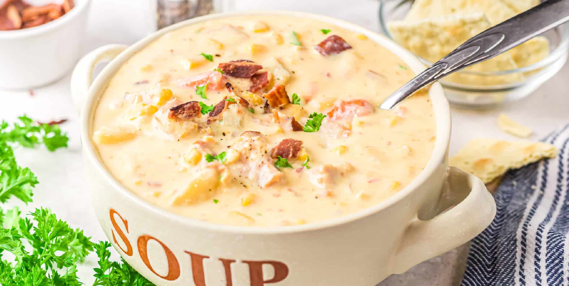 Wide view of the top of a bowl filled with potato soup and topped with bacon