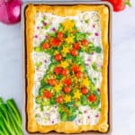 Veggie pizza cold appetizer on the pan decorated like a Christmas tree with vegetables from overhead