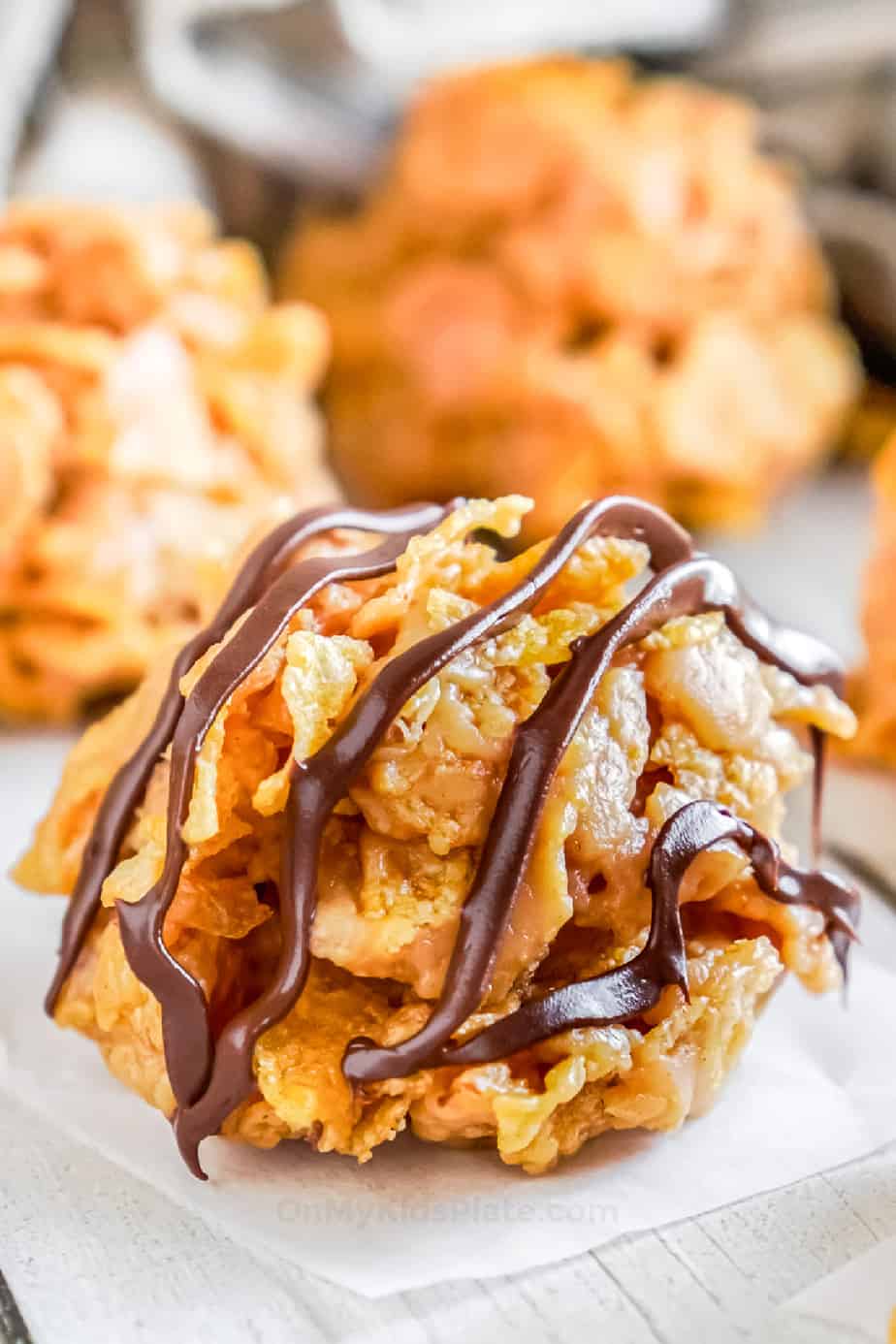 Cornflake cookie from the side drizzled with chocolate up close