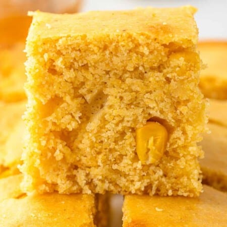 Close up side view of cornbread stacked on other pieces
