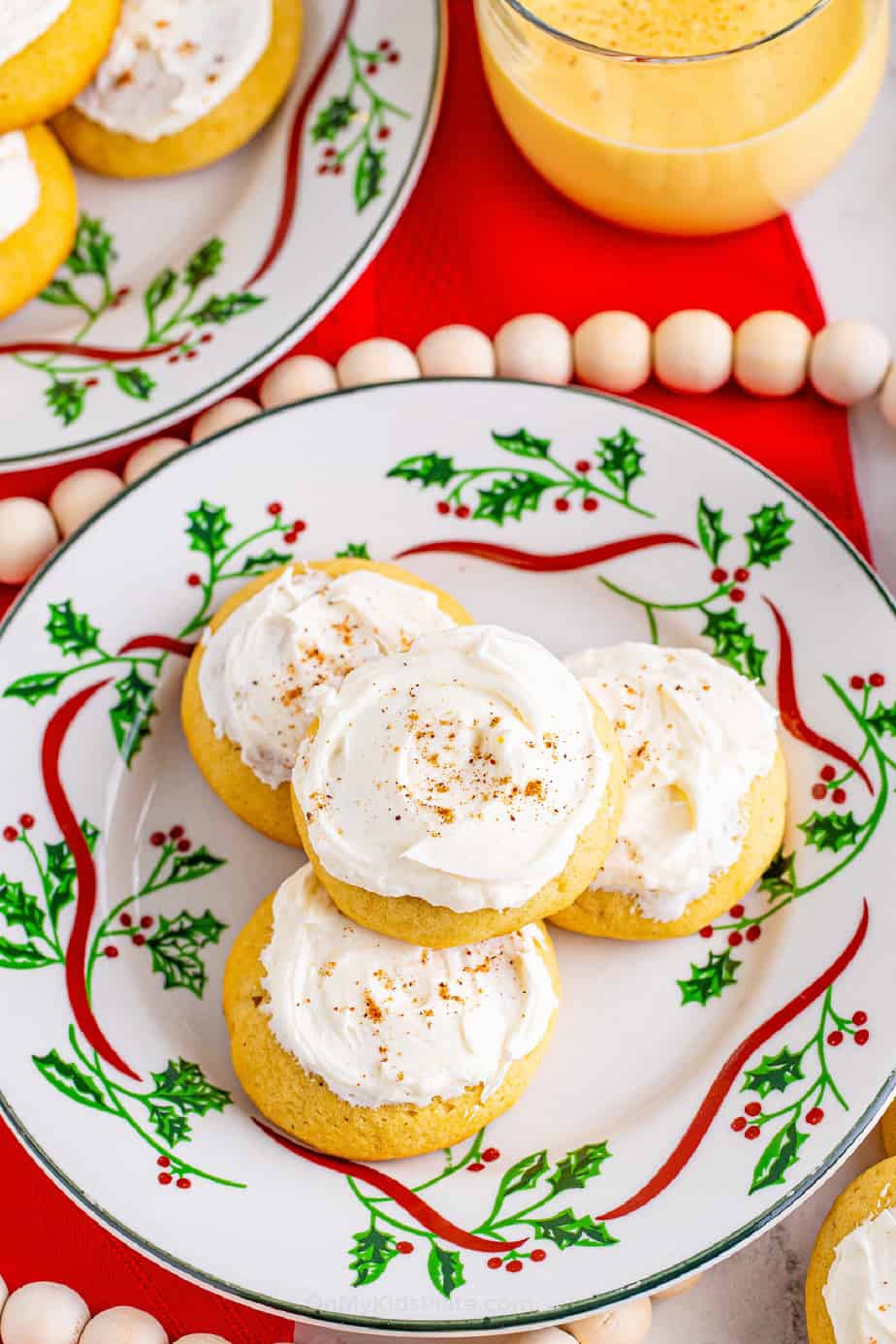 holiday plate stacked with frosted eggnog cookies on a holiday table