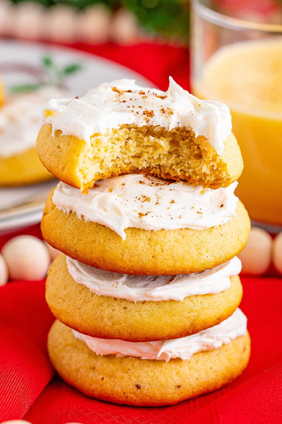 Stacked frosted eggnog cookies on a holiday table from the side