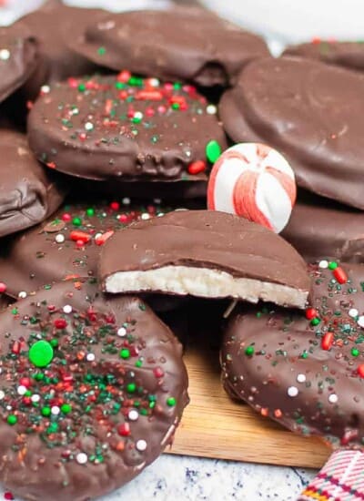 Close up of a stack of peppermint patties stacked on a cutting board with one with a bite