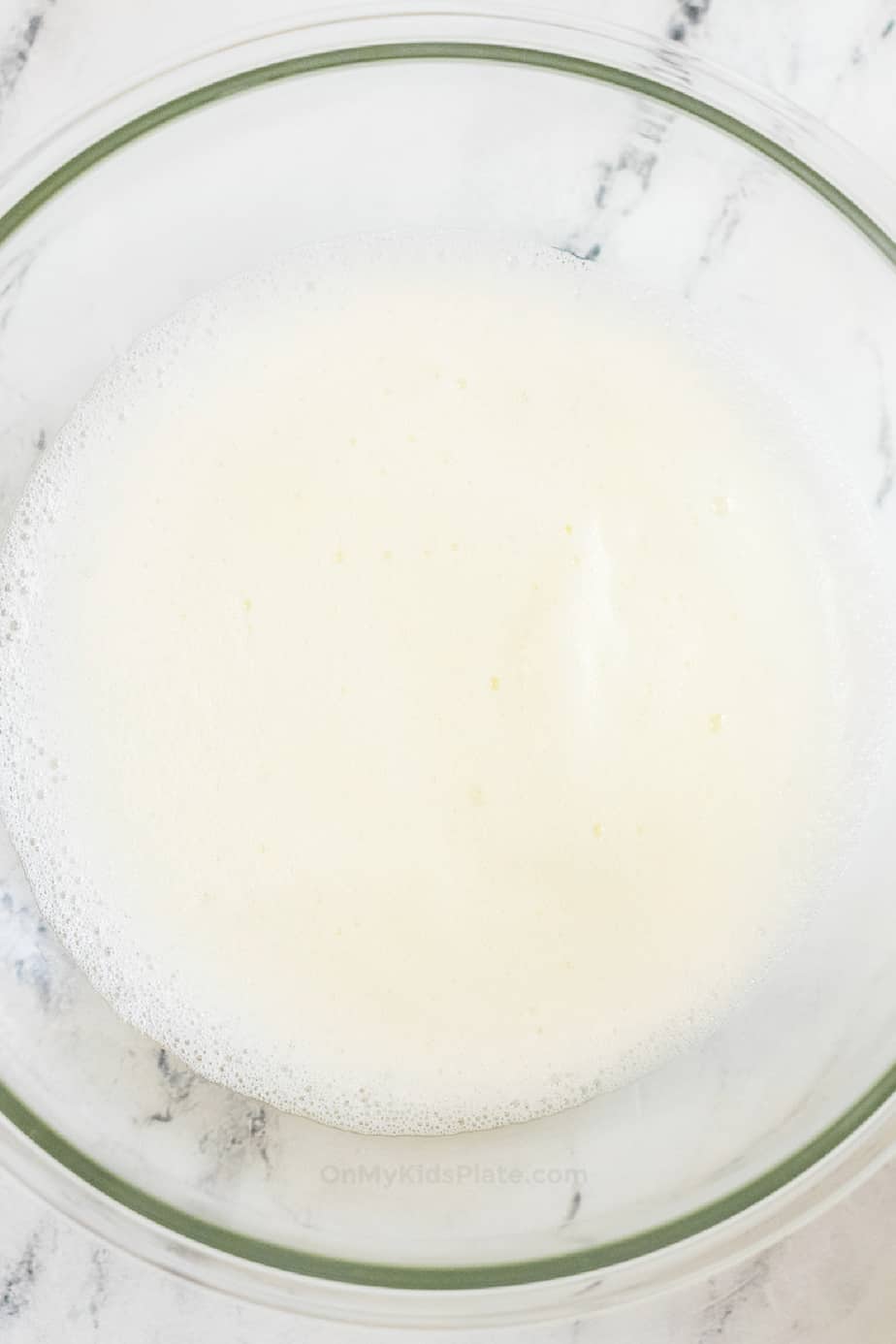 Egg whites whipped and frothy in a bowl