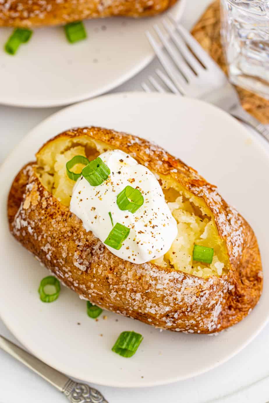 Baked potato with sour cream topping on a plate