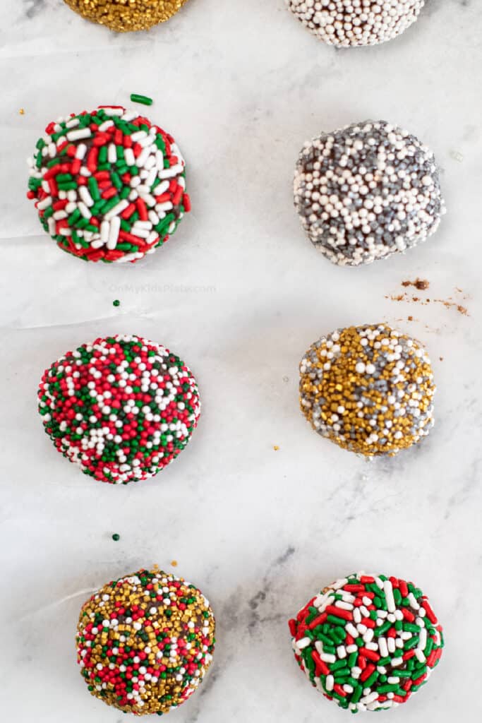 Finished brownie truffles up close rolled in sprinkles on parchment paper