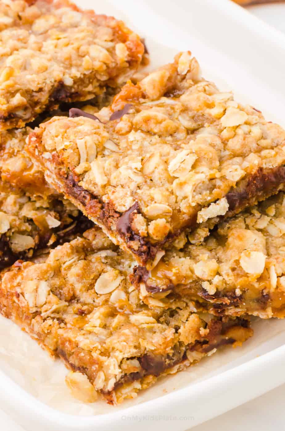 Chocolate oat carmel bars on a serving platter cut into squares 