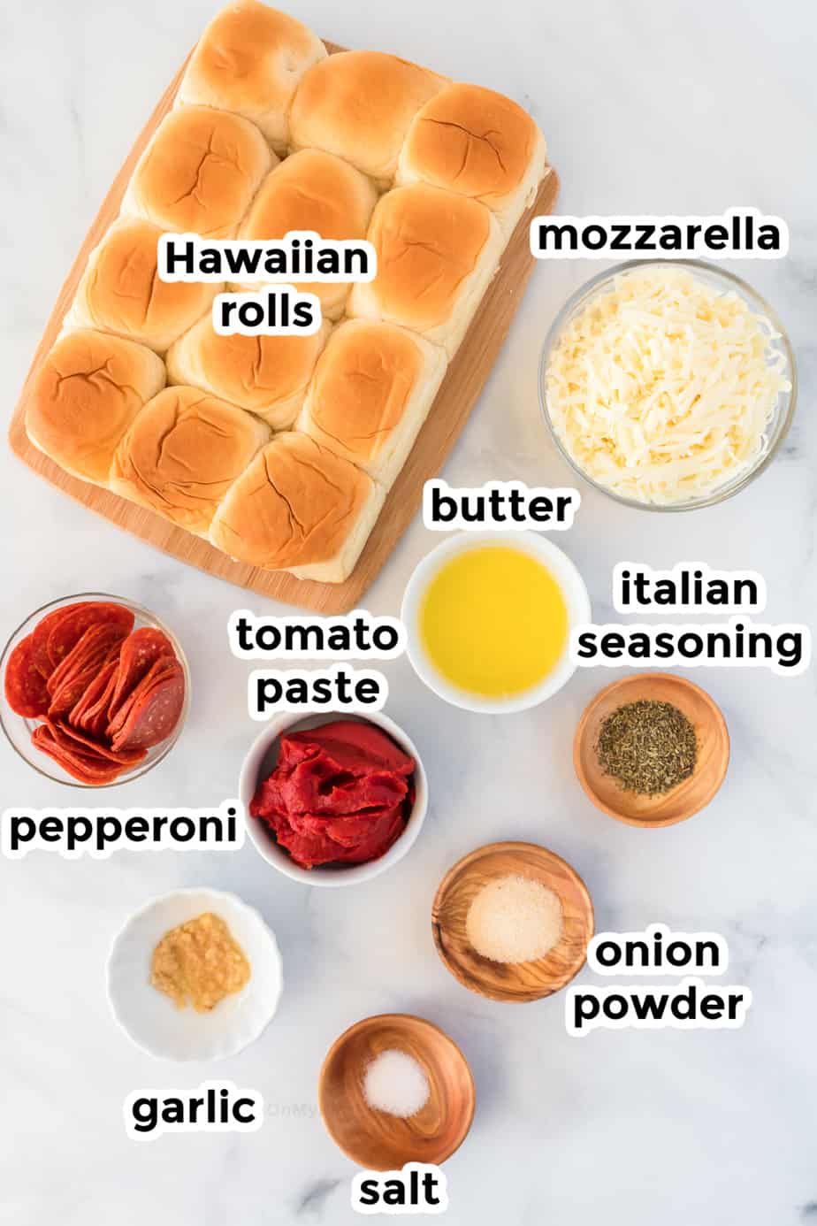 Pizza slider ingredients on a table in bowls with labels