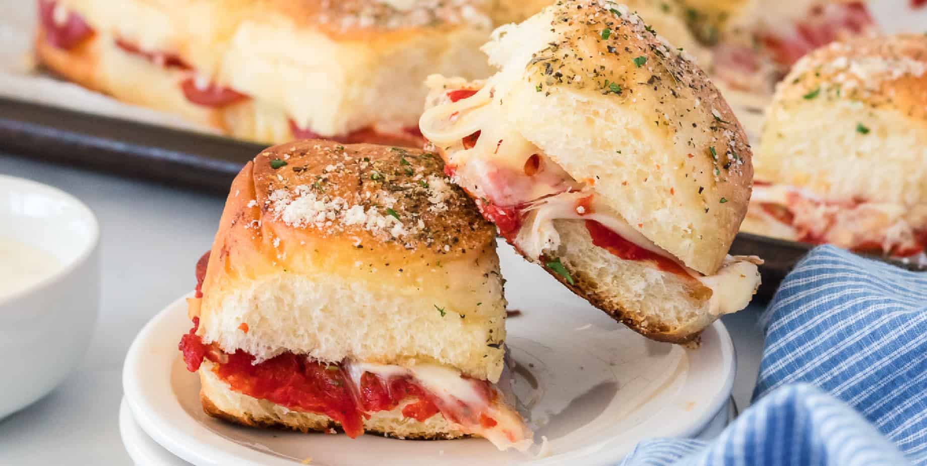 Wide side view of pizza sliders stacked on a plate