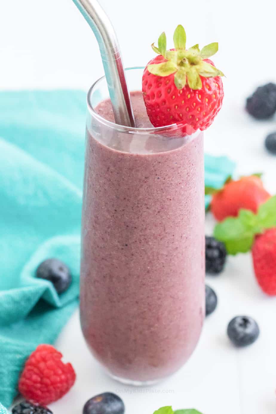 Berry smoothie in glass with strawberry and straw