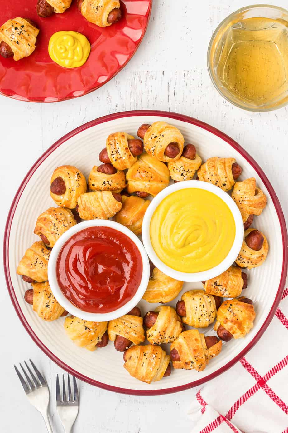 Overhead of plate full of pigs in a blanket with two dipping sauces