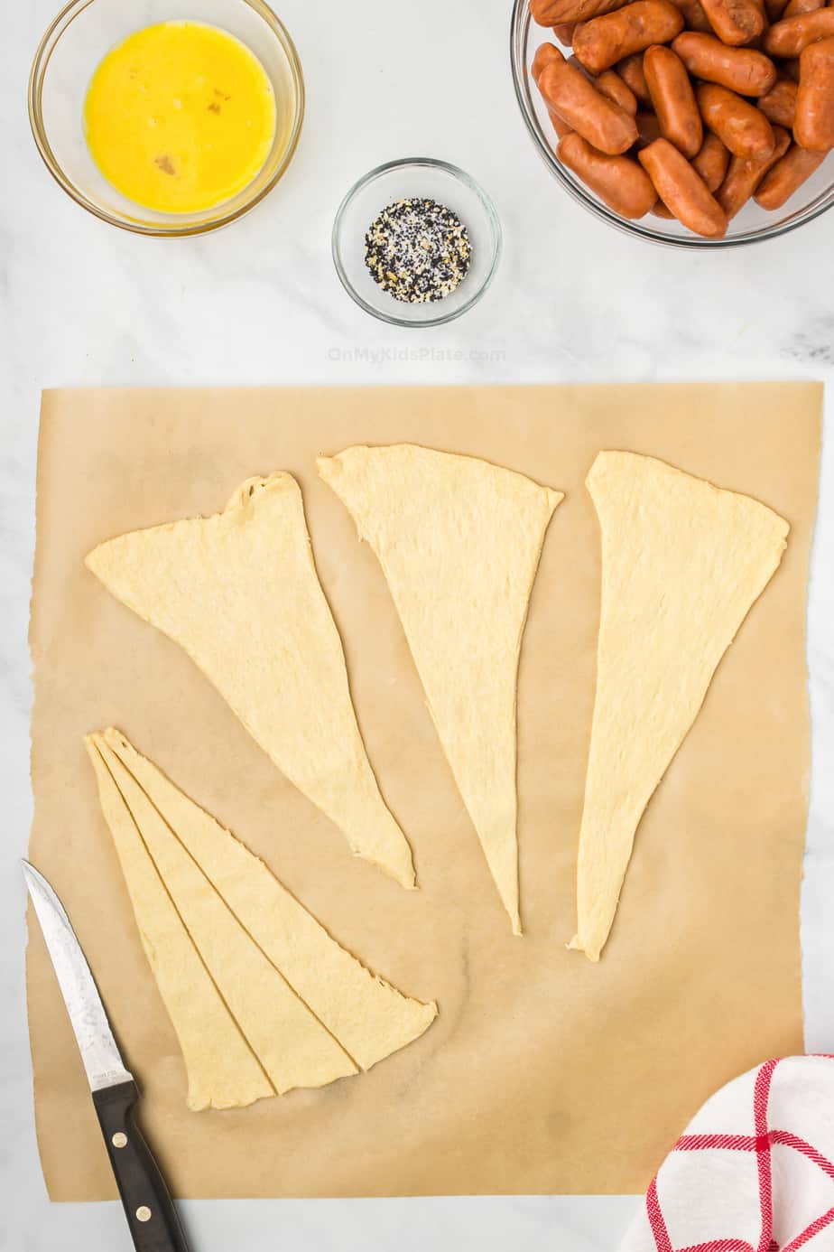 Slicing crescent roll dough into pieces with a knife