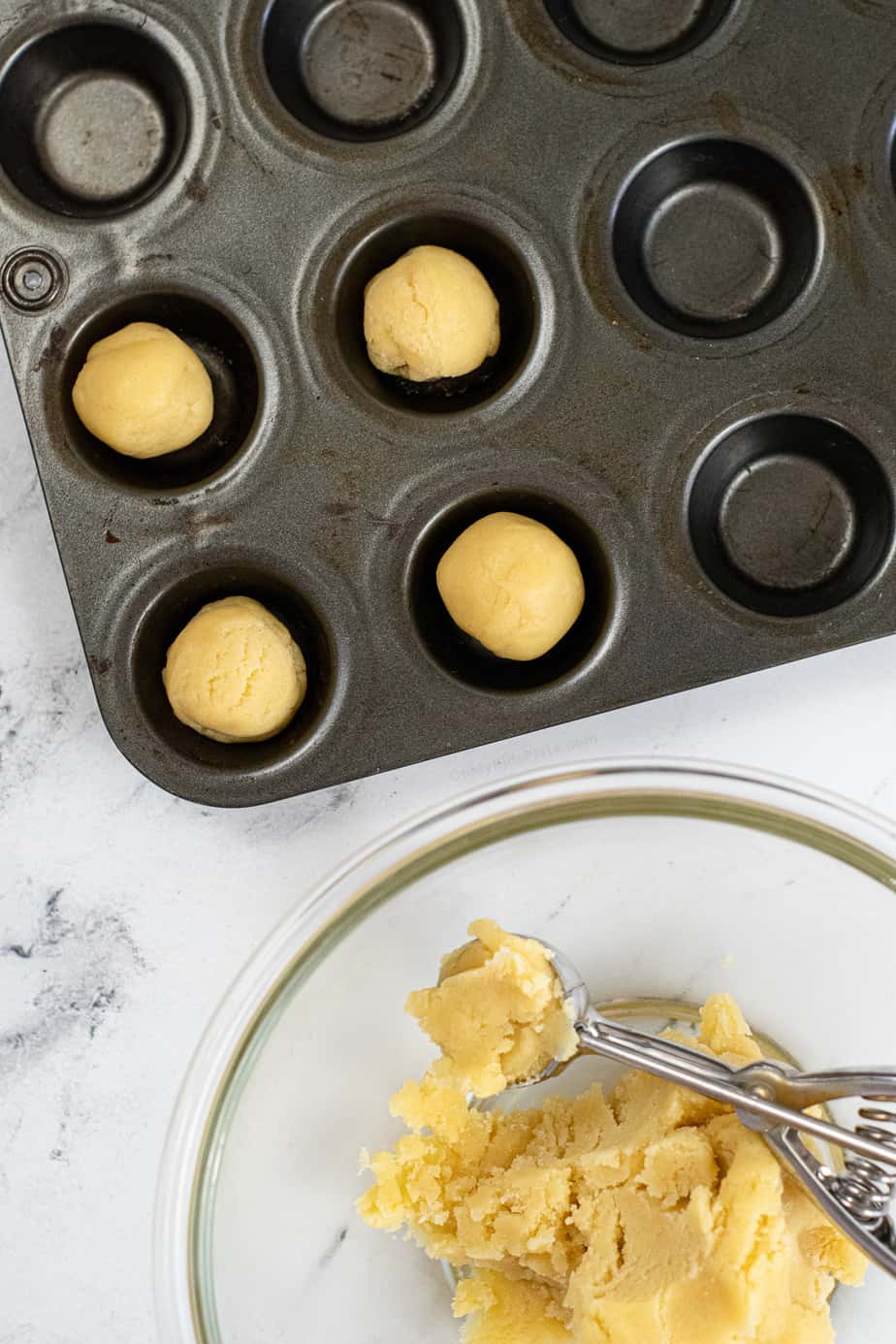 Pressing and portioning sugar cookie dough into a mini muffin pan