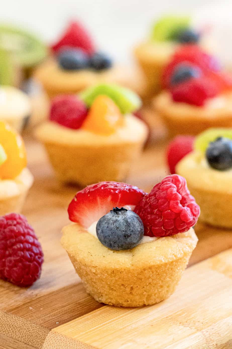 Cheesecake sugar cookie cup topped with fruit close up from the side