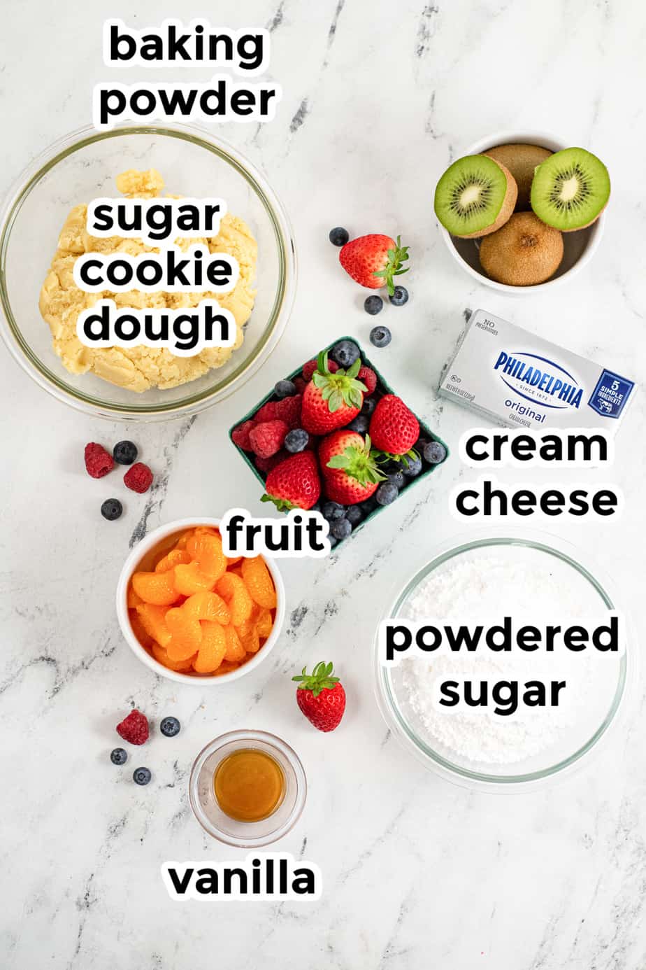 ingredients for sugar cookie cheesecake bites on a table overhead with labels