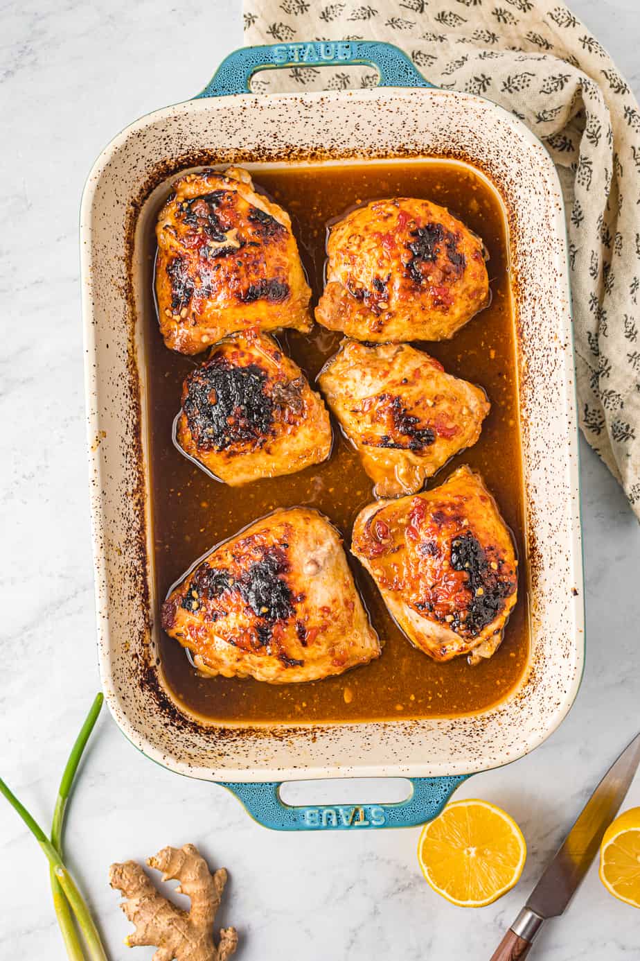 Honey garlic chicken thighs from overhead in a baking pan fully cooked sitting in sauce