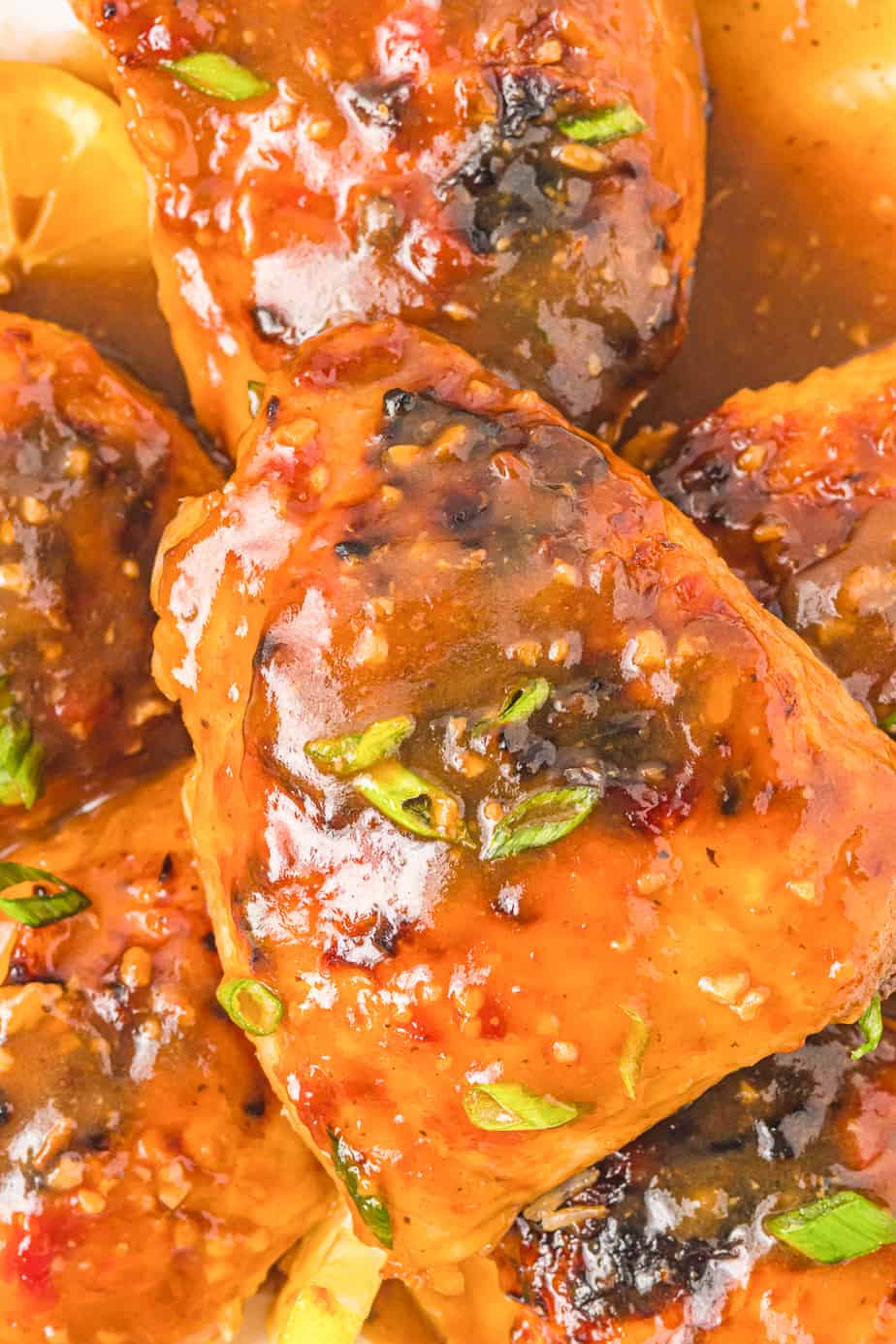Close up on a plate of baked honey garlic chicken thighs covered in sauce