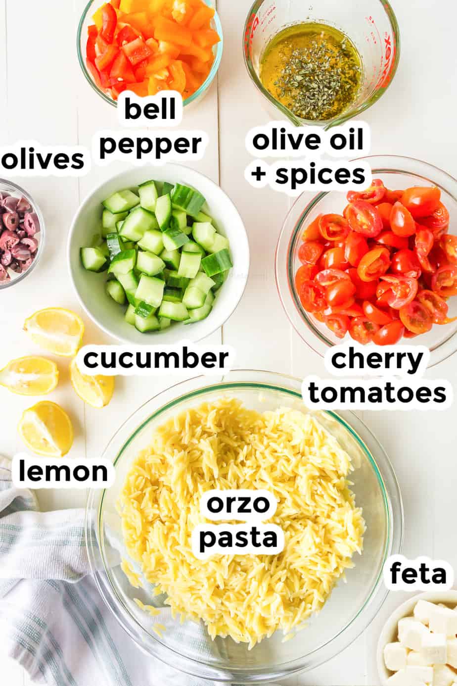 Ingredients in bowls with labels for greek orzo cold pasta salad