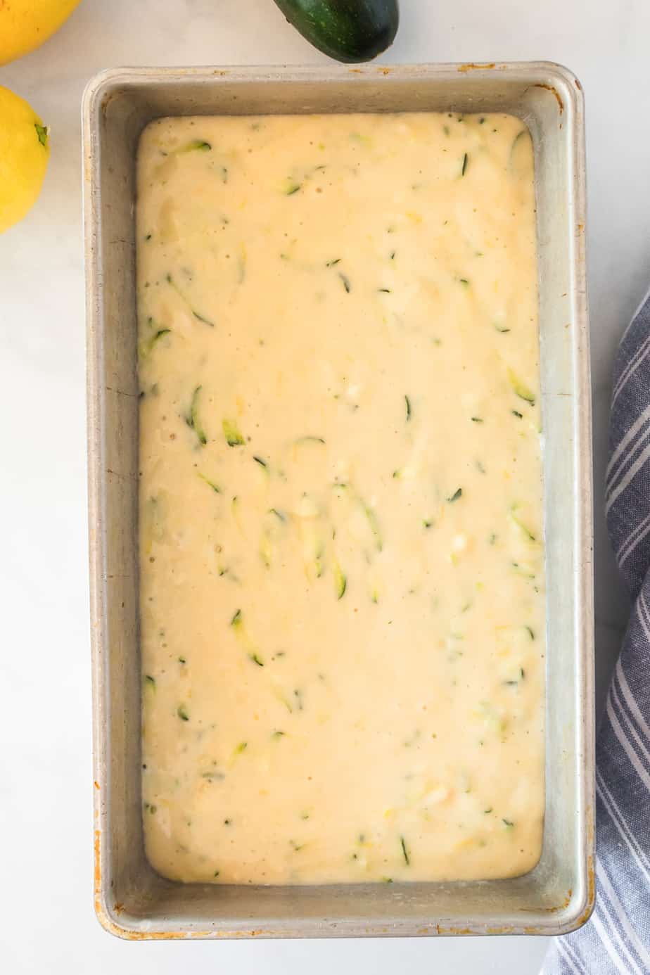 Lemon zucchini cake batter in a greased pan from above