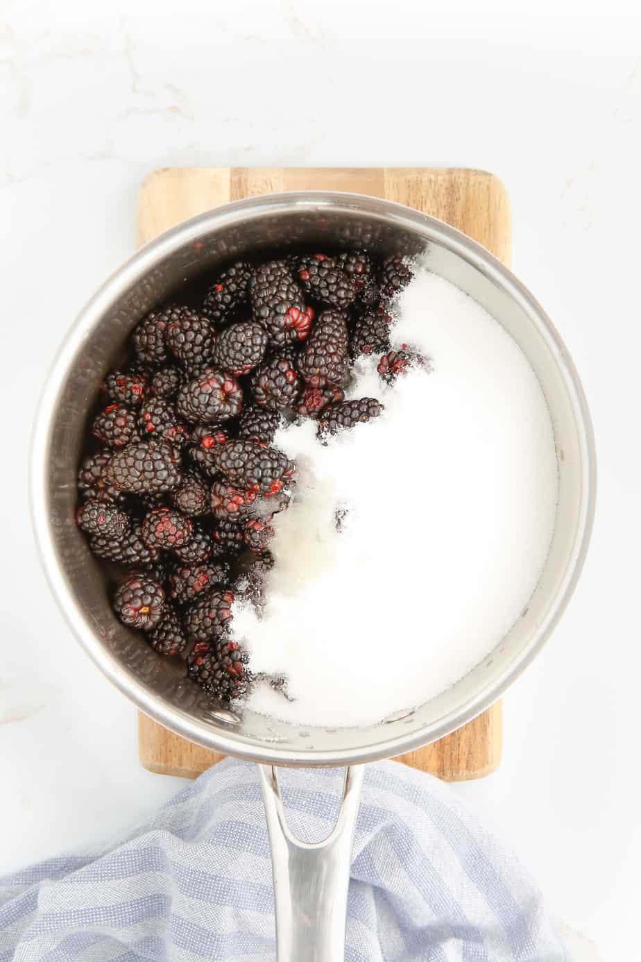 Blackberries sugar and lemon juice in a pot from above