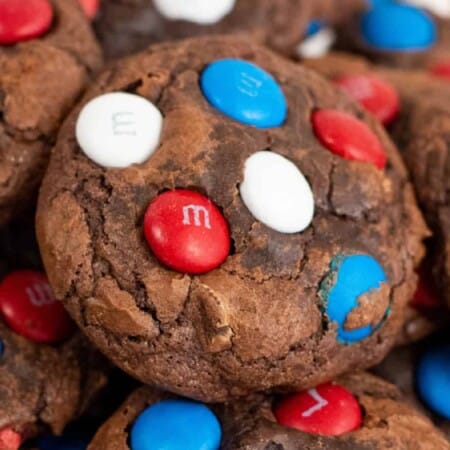 Close up of a fudgy brownie cookie topped with red, white and blue candies.