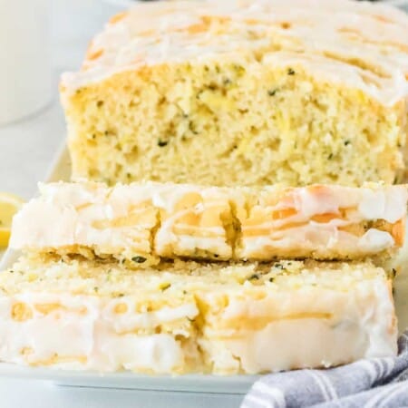Lemon yellow loaf cake sliced topped with glaze.