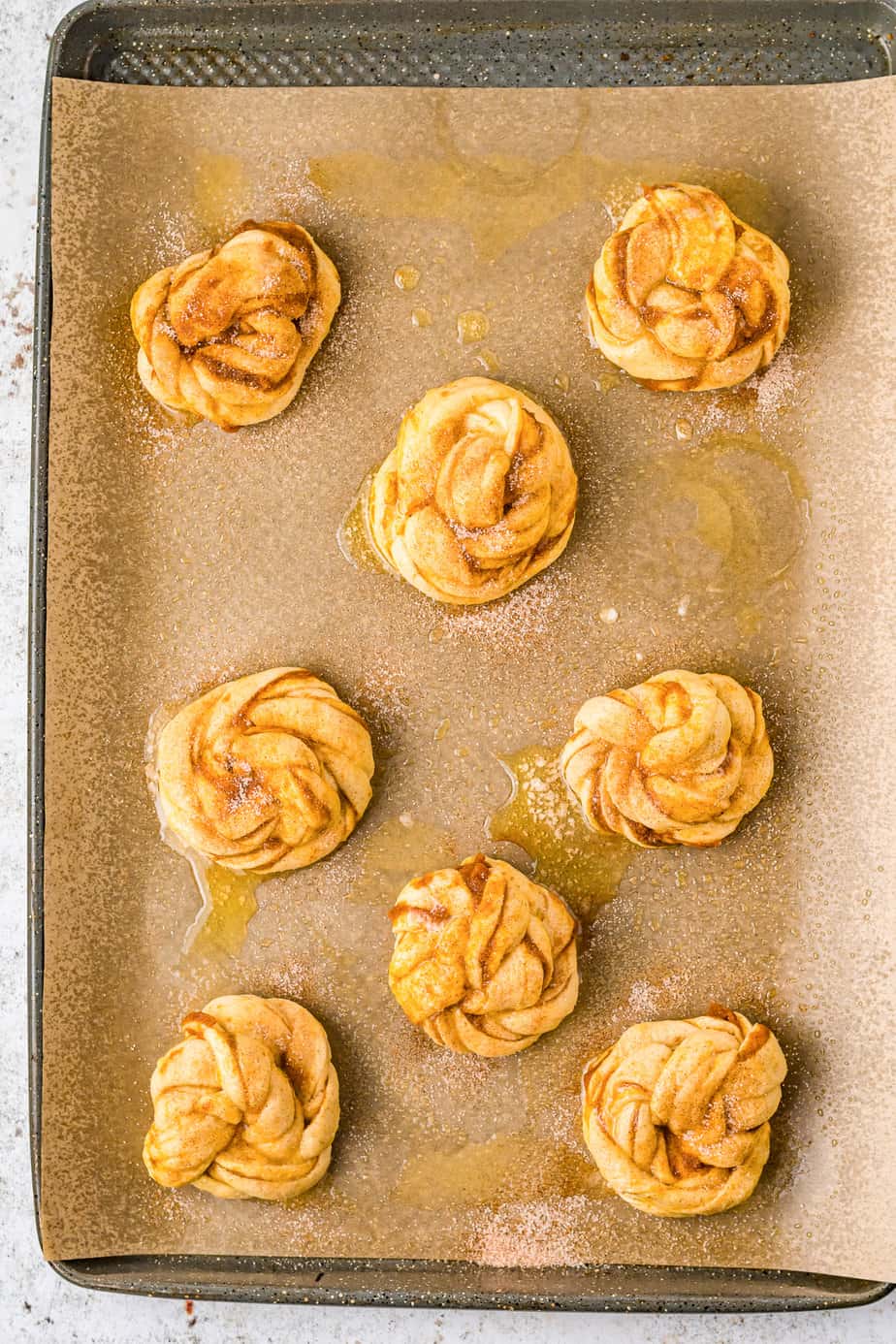 Pumpkin Crescent Roll pastries uncooked on a pan.