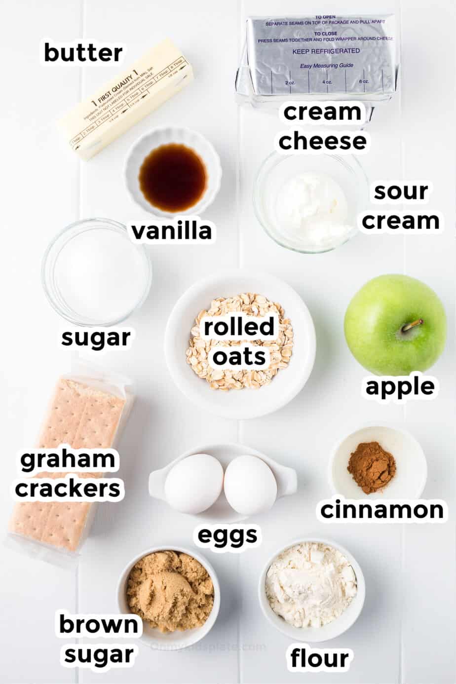 Ingredients for caramel apple cheesecake bars in bowls from overhead with labels.